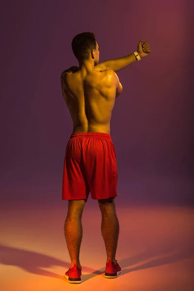 Back View Athleltic Man Röda Shorts Värmer Upp Lila Bakgrund — Stockfoto