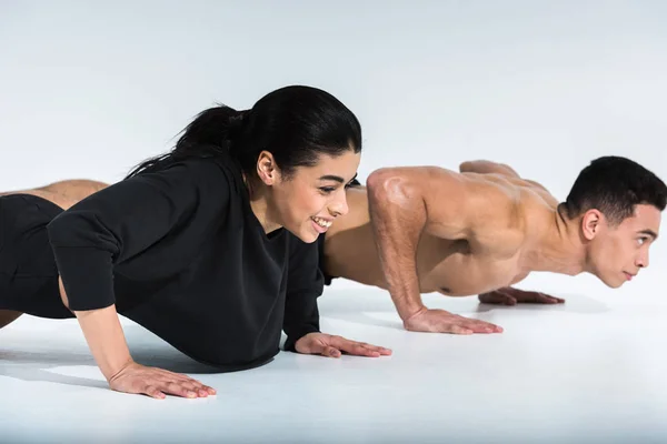 Lächelnde Afroamerikanerin Und Mixed Race Mann Machen Liegestütze Auf Weiß — Stockfoto