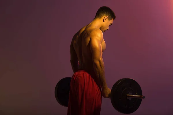 Sportive Mixed Race Man Red Shorts Holding Barbell Purple Background — Stock Photo, Image