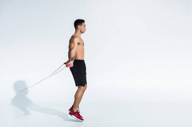 siyah şort ve kırmızı spor ayakkabı sportif karışık yarış adam yan görünümü beyaz ip atlama ile atlama