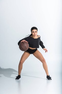 çekici sportif afro-amerikan kız top oynarken ve beyaz kamera bakarak