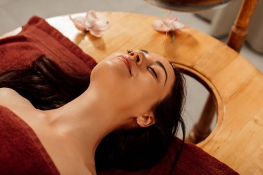 ayurvedik işlem sırasında kapalı gözlerle yatan rahat genç kadının havai görünümü