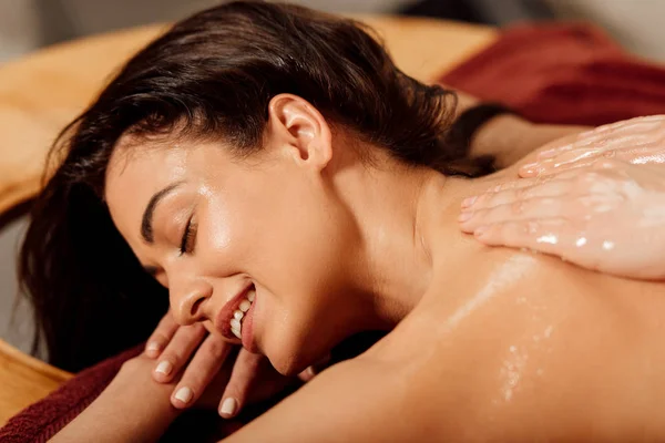 Lachende Jonge Vrouw Liggend Met Gesloten Ogen Tijdens Ayurvedische Massage — Stockfoto