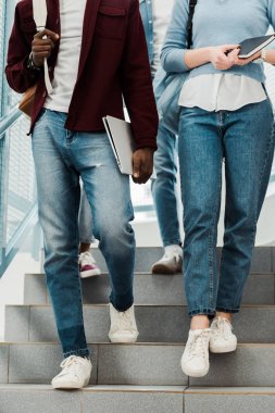 merdivenlerde dizüstü bilgisayar ve dizüstü bilgisayar ile çok kültürlü öğrencilerin kısmi görünümü