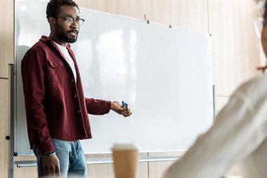 flipchart yakınında duran gözlük afro-amerikan öğrenci