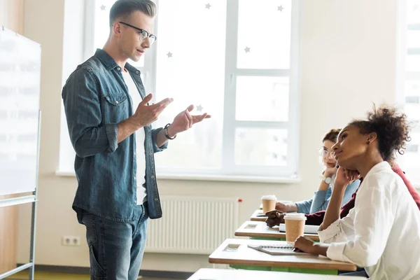 Studentin Brille Und Jeanshemd Steht Vor Schreibtischen Und Spricht Mit — Stockfoto