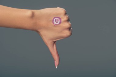 elinde viber logosu olan kadının gri üzerinde izole başparmak aşağı gösteren kısmi görünümü