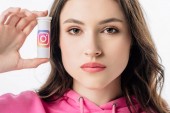 schöne Mädchen mit Behälter mit Instagram-Logo und Blick auf Kamera isoliert auf weiß