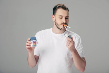 gri izole instagram logosu ile ağız tutan paketi sigara ile yakışıklı genç adam