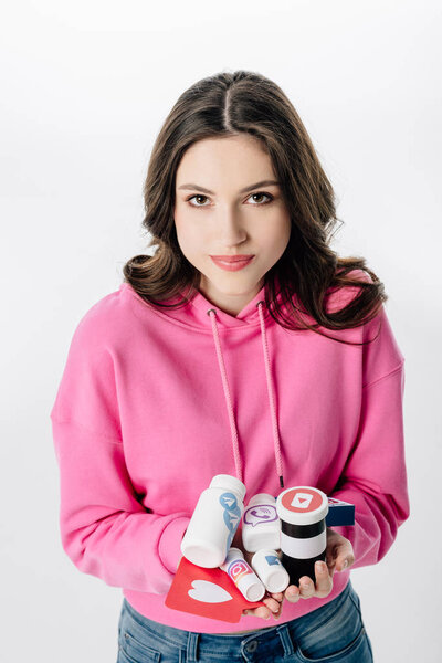 высокий угол обзора привлекательной девушки, держащей контейнеры с логотипами социальных сетей и красной карточкой с вырезанным сердцем, изолированным на белом
