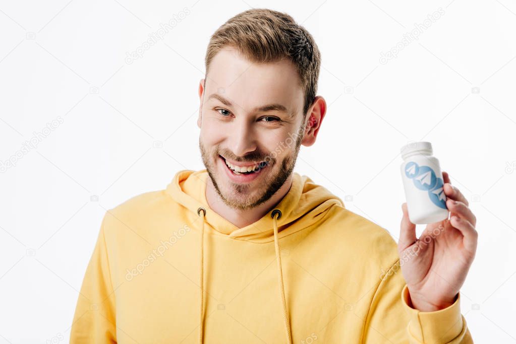 Young cheerful man holding container with telegram logo and looking at camera isolated on white