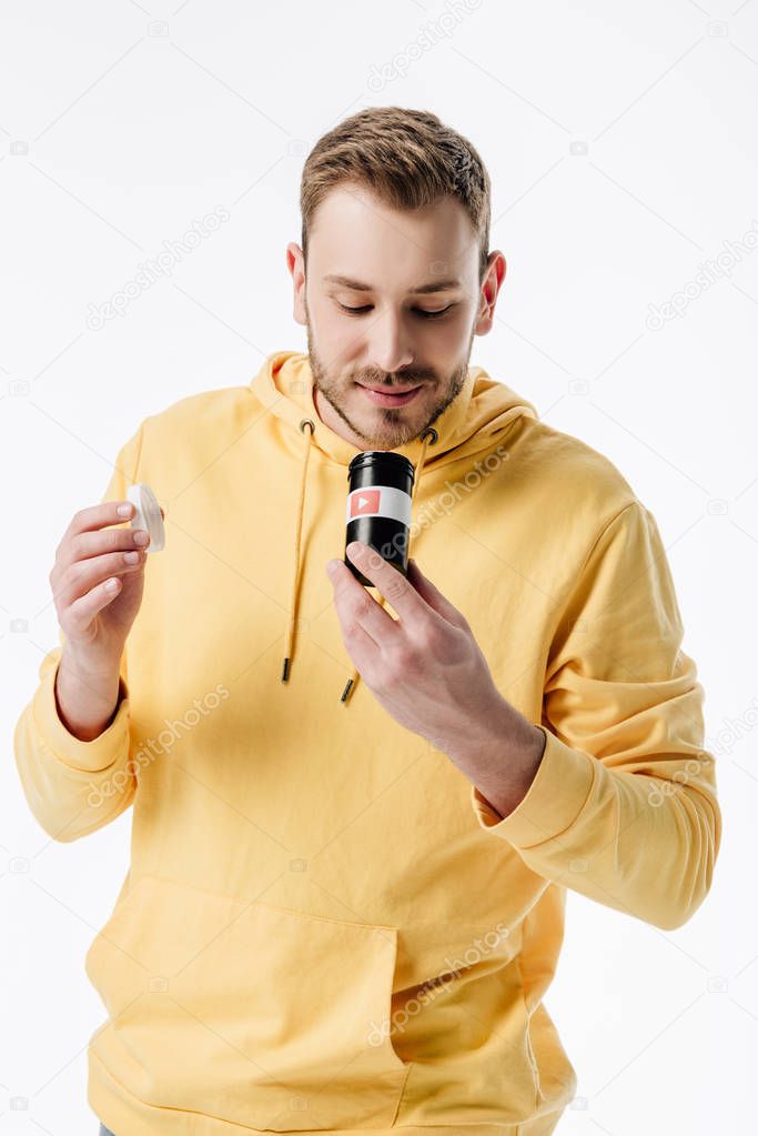 Handsome young man looking into container with youtube logo isolated on white