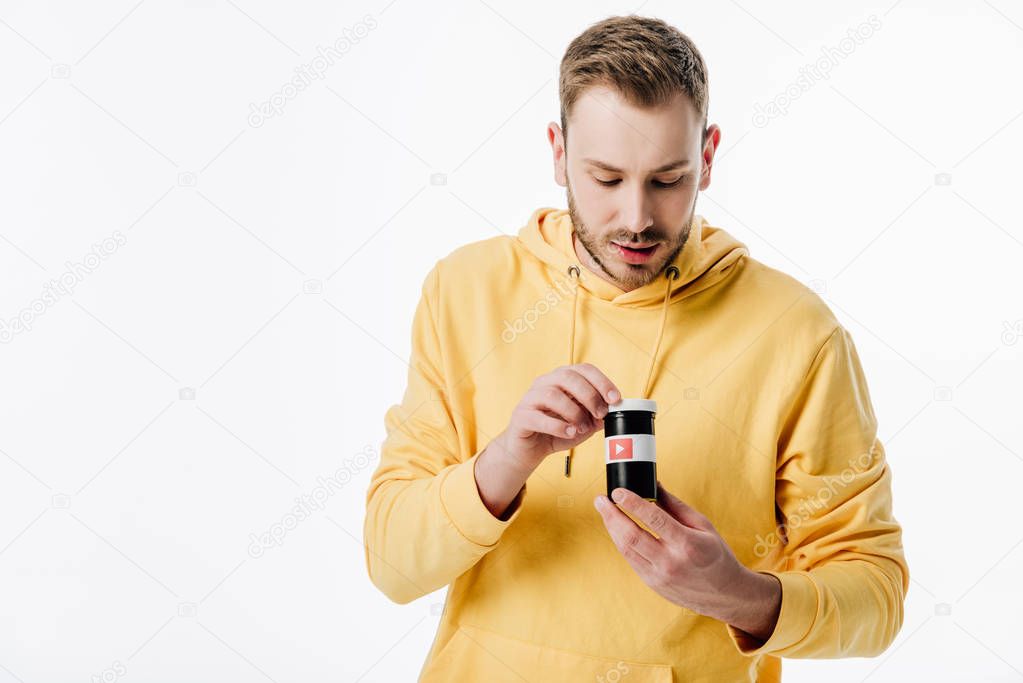 Handsome young man looking into container with youtube logo isolated on white