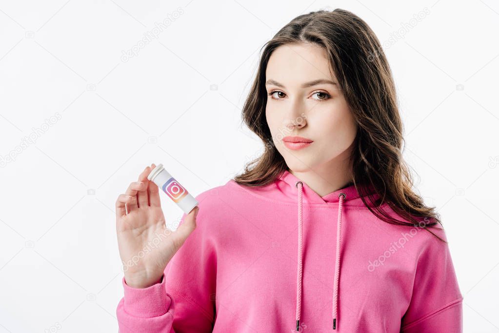Smiling young woman holding container with instagram logo and looking at camera isolated on white