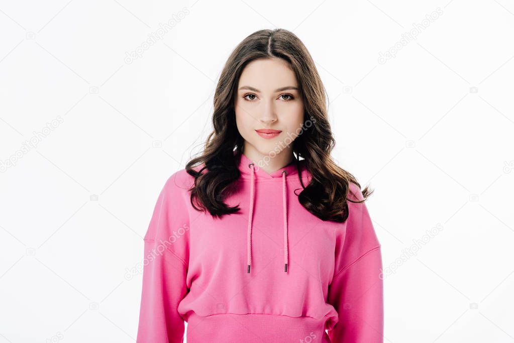 attractive confident girl in pink hoodie looking at camera isolated on white