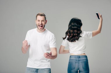 gri izole selfie çekerken kazanan jest gösteren akıllı telefon ile heyecanlı genç adam
