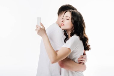 beyaz izole erkek arkadaşı ile kucaklayan ise akıllı telefon kullanarak güzel genç kız