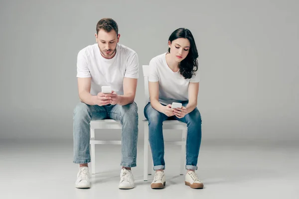 Hombre Mujer Concentrados Camisetas Blancas Vaqueros Azules Sentados Sillas Usando — Foto de Stock