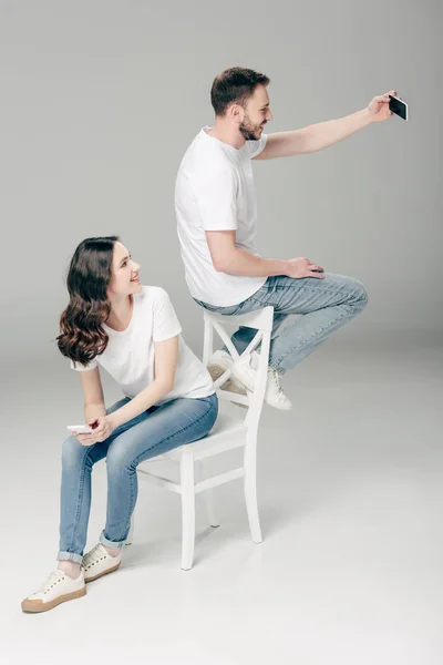 Menina Sorrindo Olhando Sentado Cadeira Olhando Para Homem Alegre Tomando — Fotografia de Stock