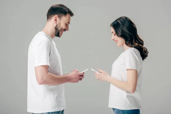 Vista Lateral Jovem Sorridente Mulher Camisetas Brancas Usando Smartphones Isolados — Fotografia de Stock