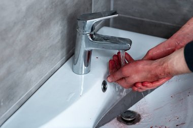 partial view of man washing bleeding hands in sink clipart