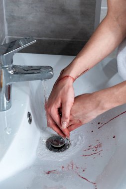partial view of woman washing bleeding hands in bathroom clipart