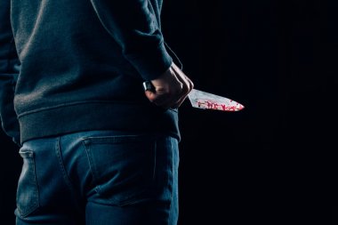 cropped view of murderer holding knife isolated on black clipart