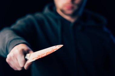 selective focus of killer holding knife isolated on black clipart