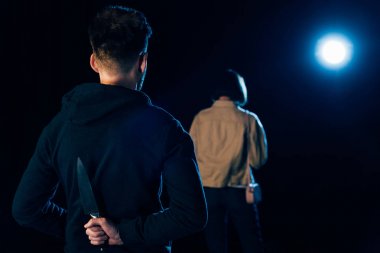 katilin bıçağı sakladığını ve siyah ın üzerinde kurbana baktığının arka görünümü