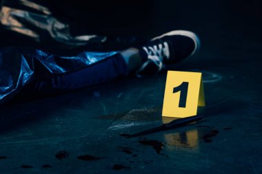 partial view of covered dead body near evidence marker at crime scene clipart