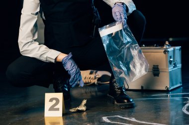 suç mahallinde delil toplayan üniformalı araştırmacının kısmi görünümü