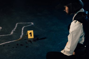 olay yerinde tebeşir anahat yakınında oturan araştırmacı nın kırpılmış görünümü