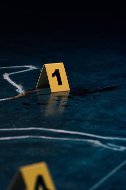 selective focus of chalk outline and evidence markers at crime scene clipart