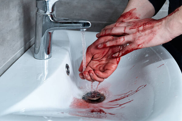 partial view of man washing bleeding hands in sink