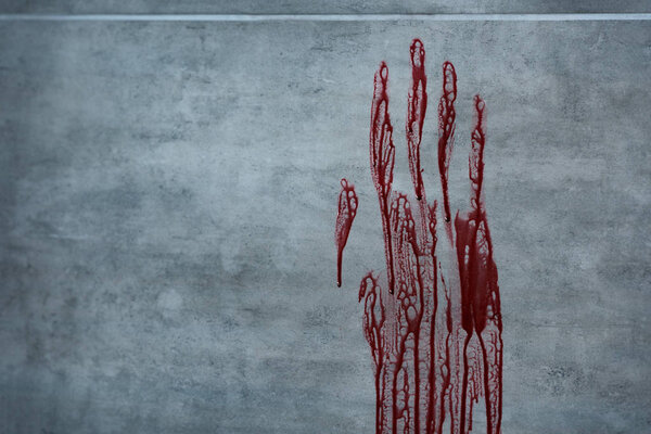 red bloody hand print on grey textured surface