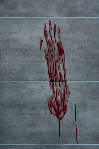 red bloody hand print on grey textured surface