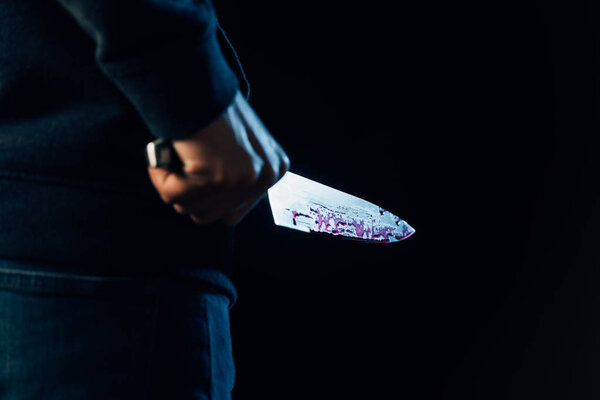 cropped view of murderer holding knife isolated on black