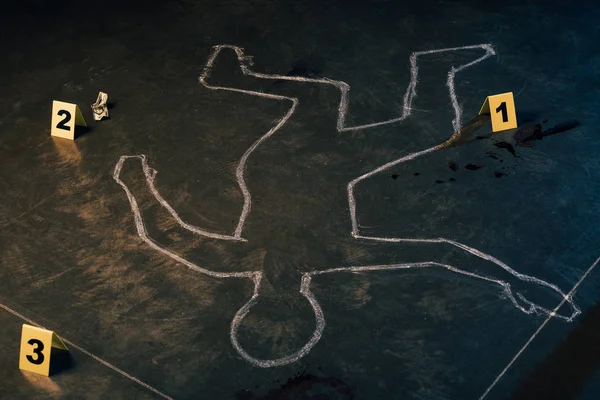 chalk outline and evidence markers at crime scene