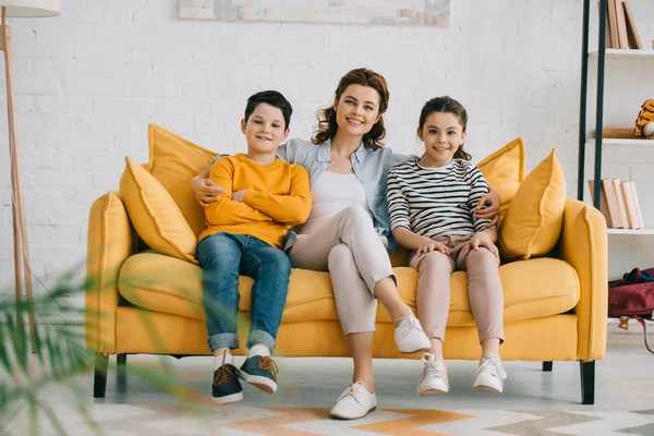 Happy Mother Cheerful Children Sitting Yellow Sofa Looking Camera — Stock Photo, Image