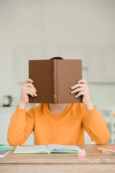 School Jongen Verbergen Gezicht Achter Boek Terwijl Zittend Bureau Het — Stockfoto