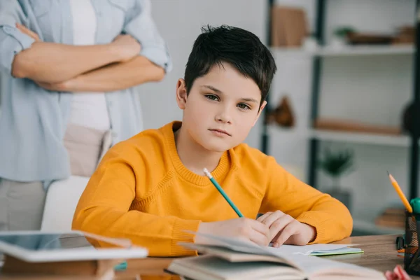 Partial View Woman Standing Crossed Arms Thoughtful Son Doing Homework — Stock Photo, Image