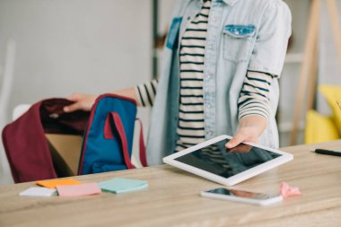 geri paketi paketlerken boş ekranile dijital tablet tutan okul çocuğunun kırpılmış görünümü
