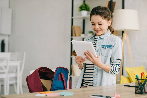 快乐的孩子拿着数字平板电脑 而站在办公桌附近在家里 — 图库照片