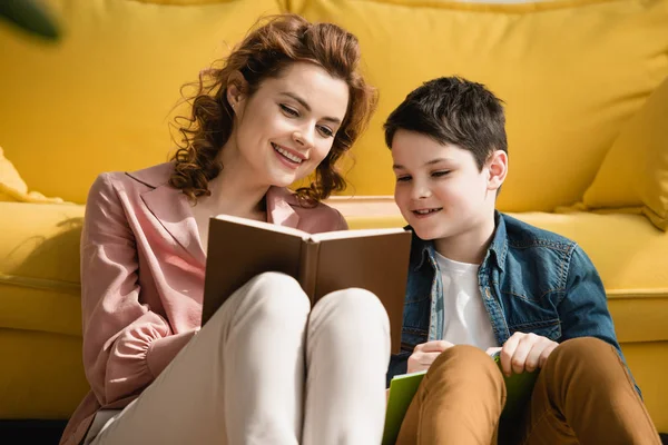 Cheerful Woman Smiling Son Sitting Floor Sofa Reading Book Together — Stock Photo, Image