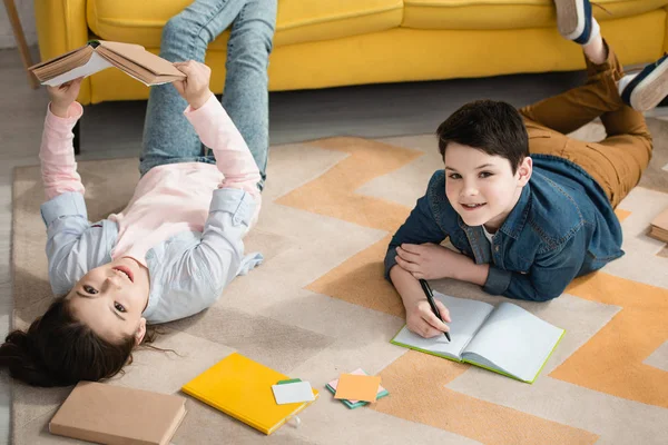 Cheerful Kids Lying Floor Home Doing Schoolwork Together — Stock Photo, Image