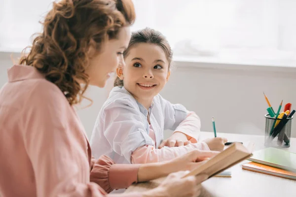 Cheerful Child Looking Beautiful Mother While Doing Homework Together — Stock Photo, Image