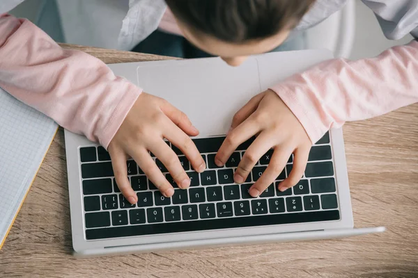Обрізаний Вид Шкільного Малюка Використовуючи Ноутбук Сидячи Столом Роблячи Домашнє — стокове фото