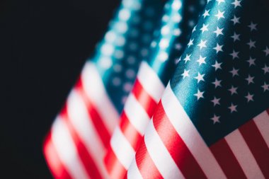selective focus of usa national flags isolated on black, memorial day concept clipart