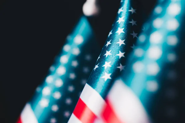 selective focus of usa national flags isolated on black, memorial day concept