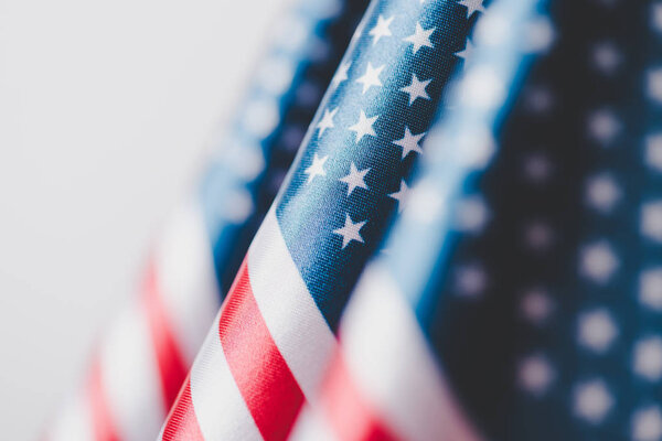 selective focus of usa national flags isolated on grey, memorial day concept